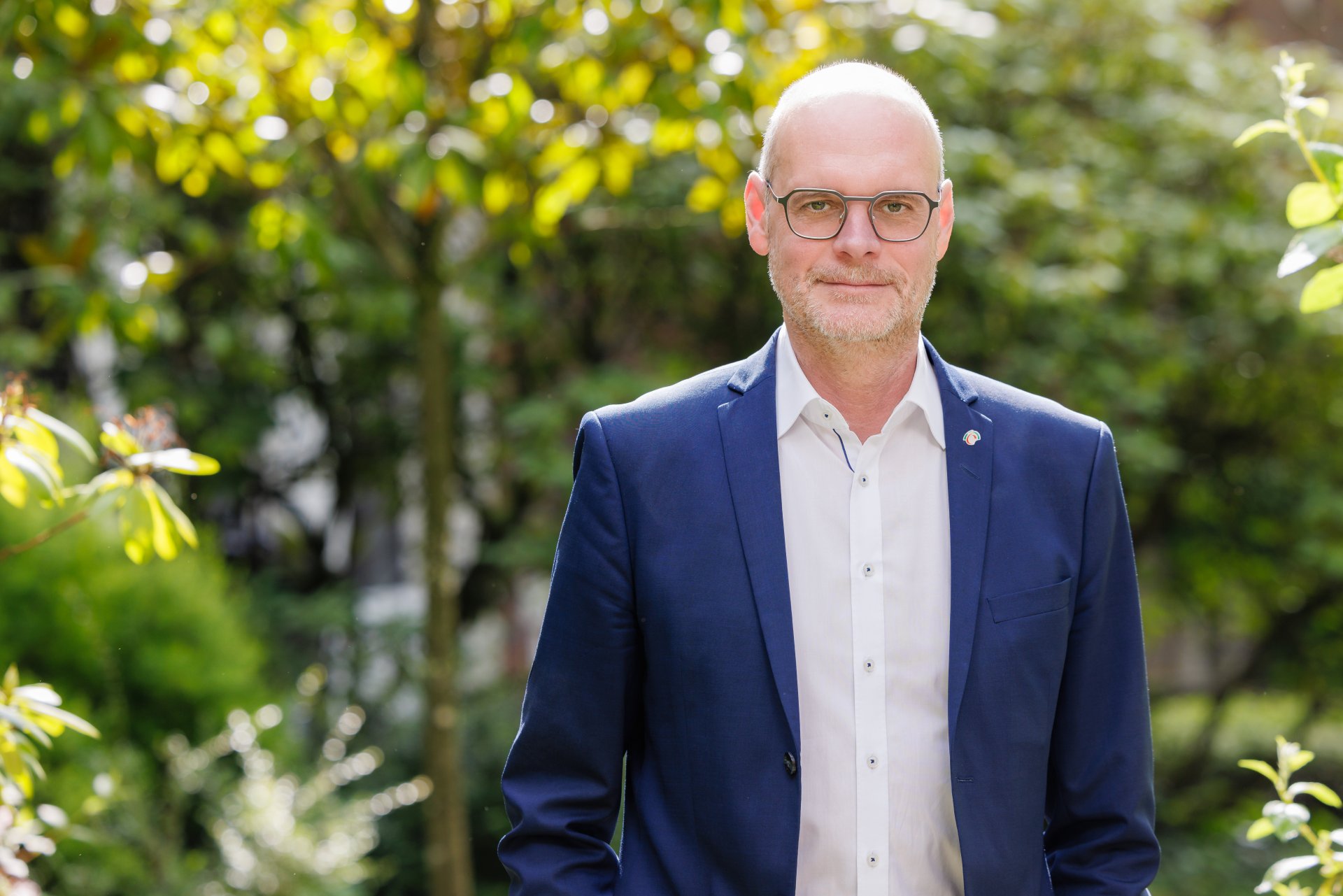 HGF Sommer Hauptgeschäftsführer Christof Sommer vor einem mit Pflanzen bewachsenen Hintergrund.