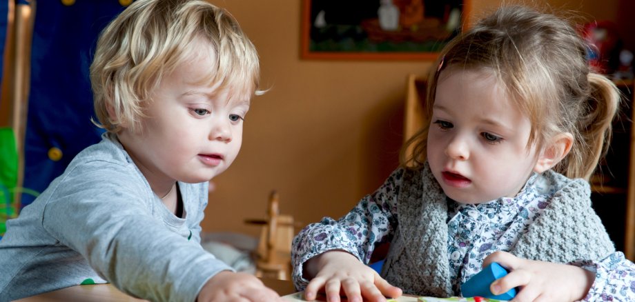 Kleine Kinder spielen mit einem Puzzle