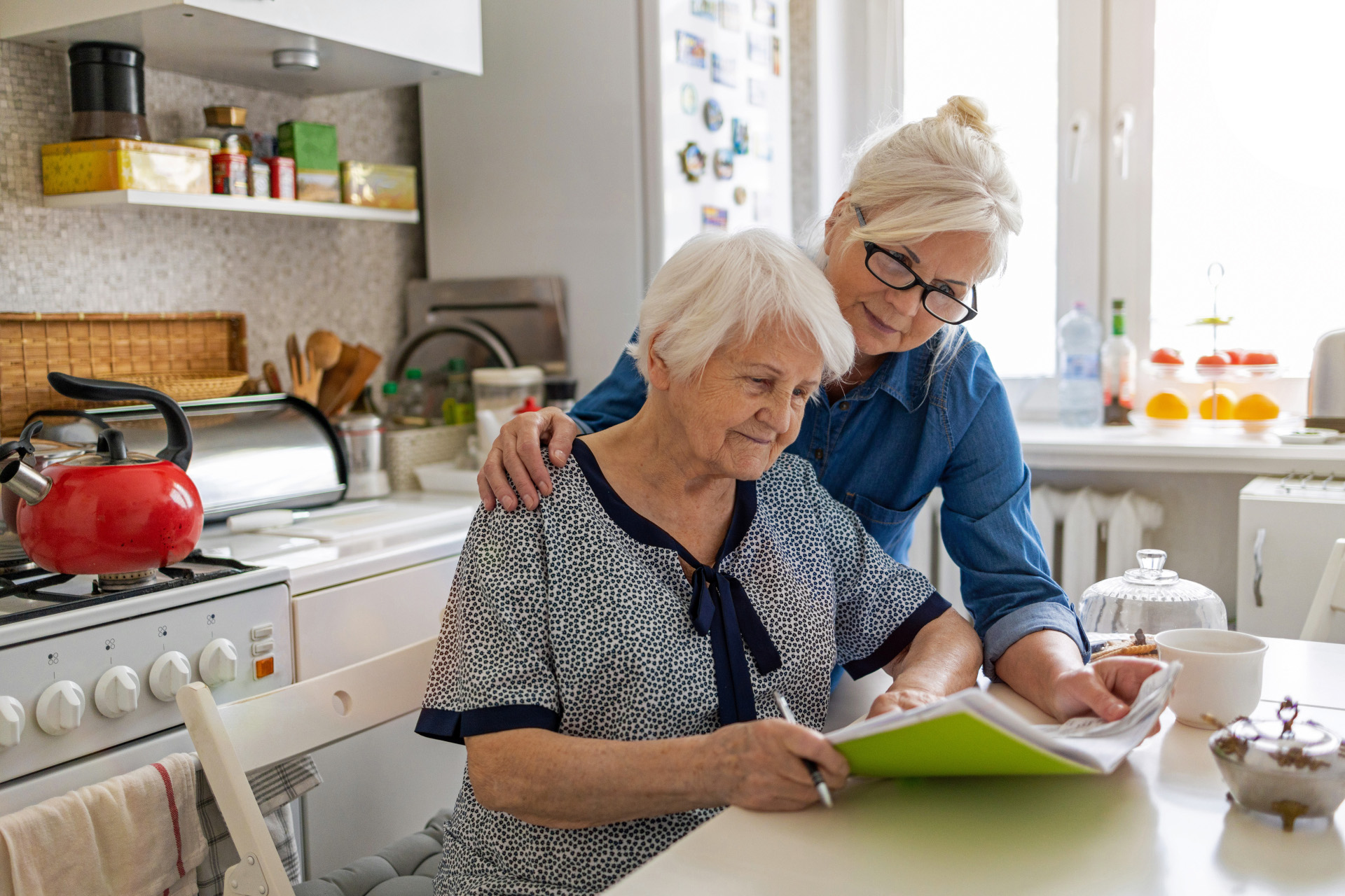 Eine Frau legt ihren Arm um eine Seniorin  Eine Frau legt ihren Arm um eine Seniorin