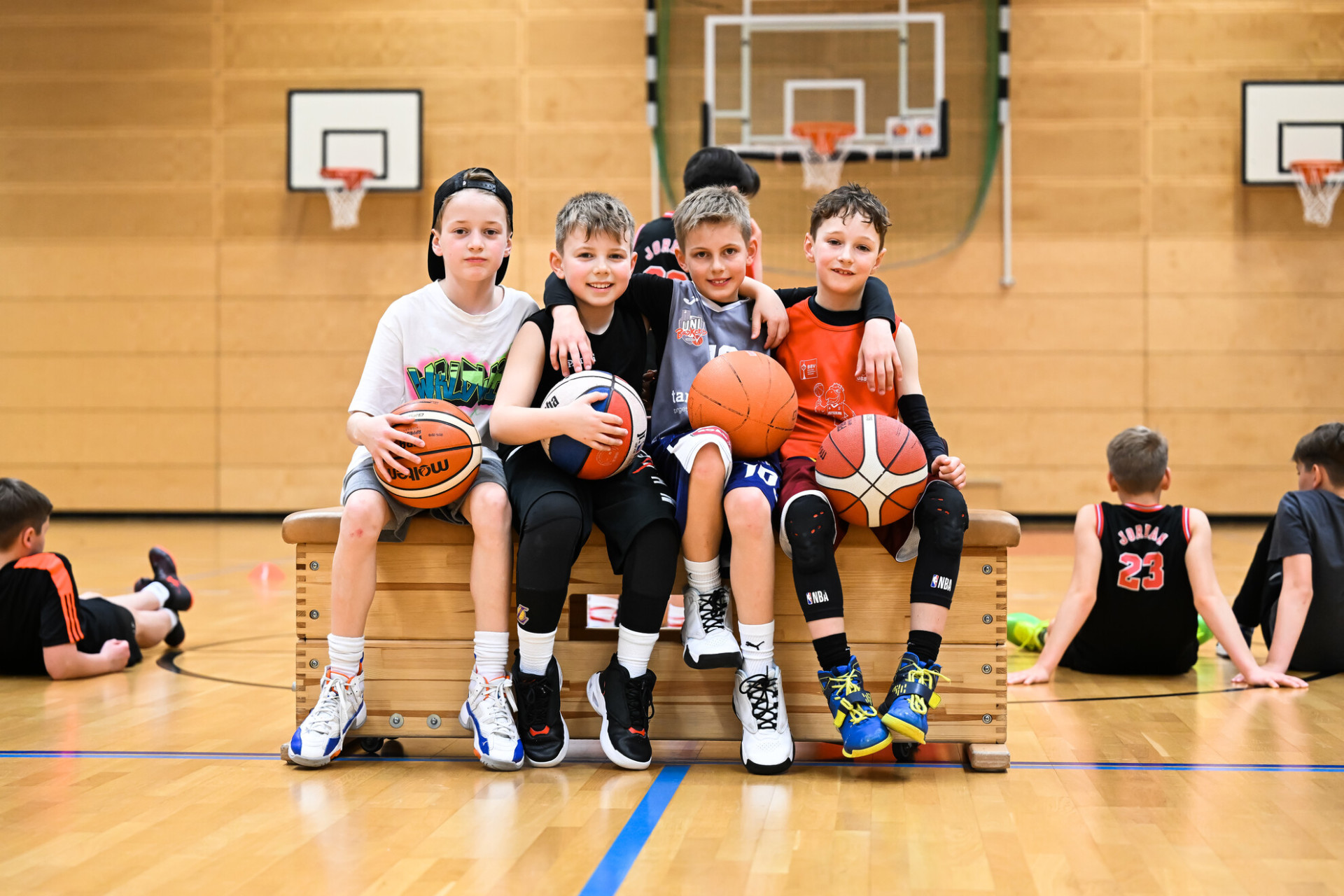 Schüler als Team mit Basketball in der Sporthalle  Kinderteam mit Basketball in der Sporthalle